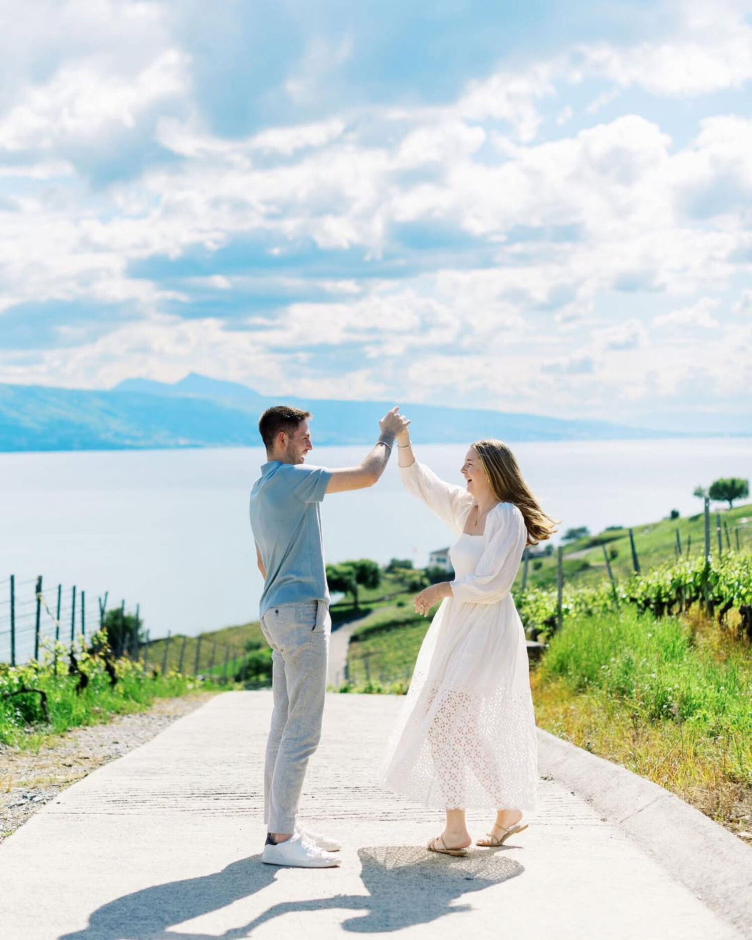 A couple standing beneath a dramatic Swiss mountain landscape